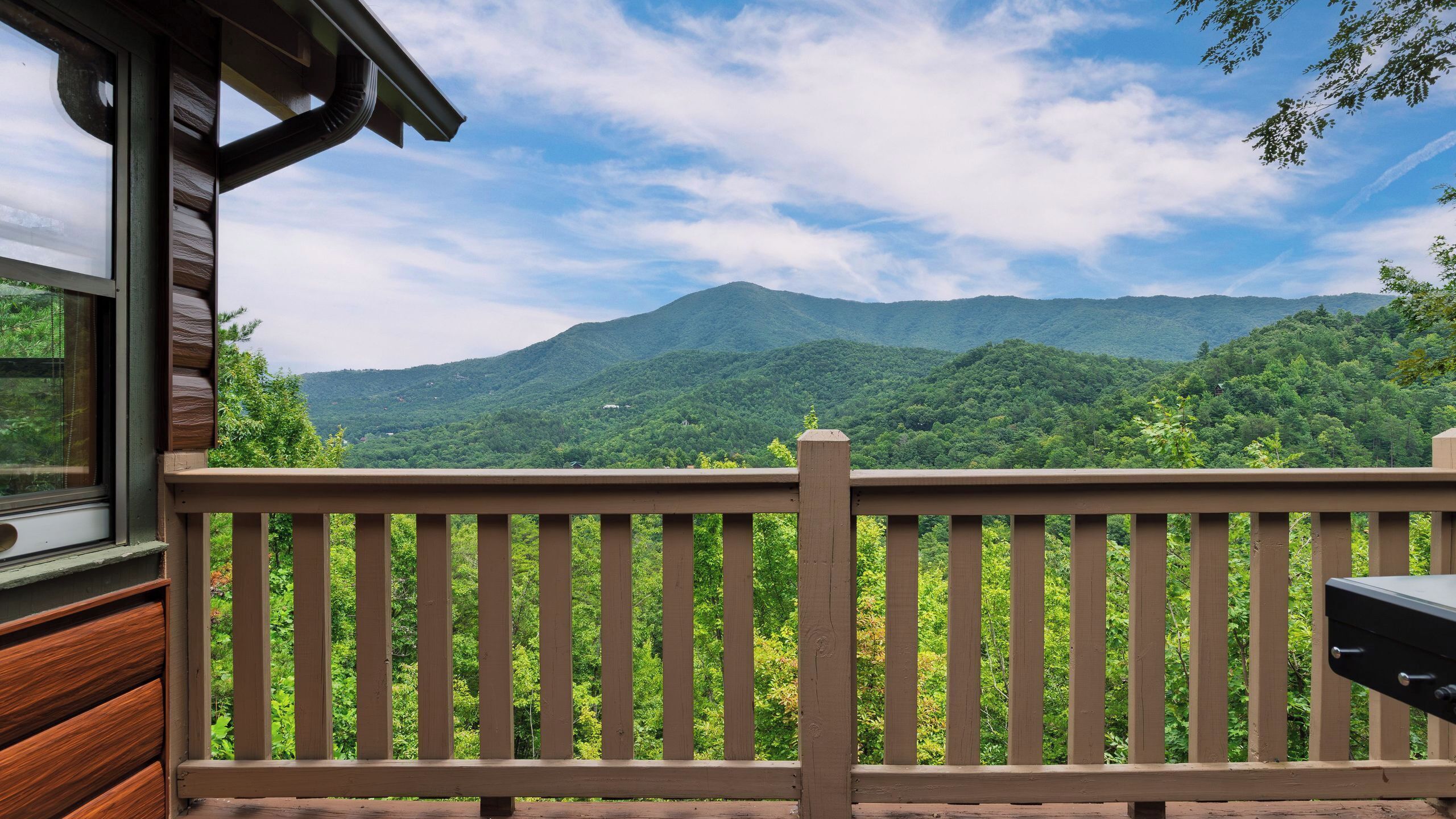 Une terrasse en bois offrant une vue sur une chaîne de montagnes.