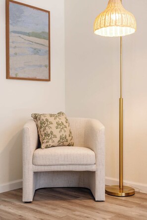 A corner room with a small armchair, a floor lamp, and a painting on the wall. - Coastal 2BR | Walk to Ocean Beach & Cafés (San Diego)