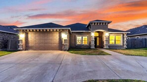 A residential house with a garage, a front porch, and a driveway. - Graceland by Avantstay Private Pool + Spa + Fenced Backyard Near North Padre Island (Corpus Christi)