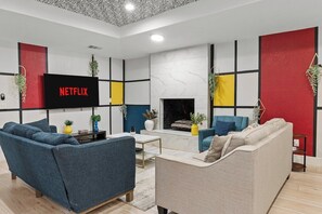 Un soggiorno moderno con camino, televisore a schermo piatto e divano.