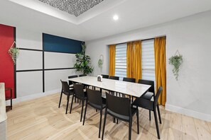 A conference room with a white table, black chairs, and a geometric wall design. - Home Theater - Game Room - Pool - Hot Tub - Golf (Plano)