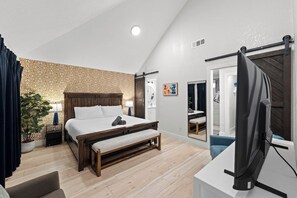 A bedroom with a bed, bedside table, lamp, and a TV. - Home Theater - Game Room - Pool - Hot Tub - Golf (Plano)