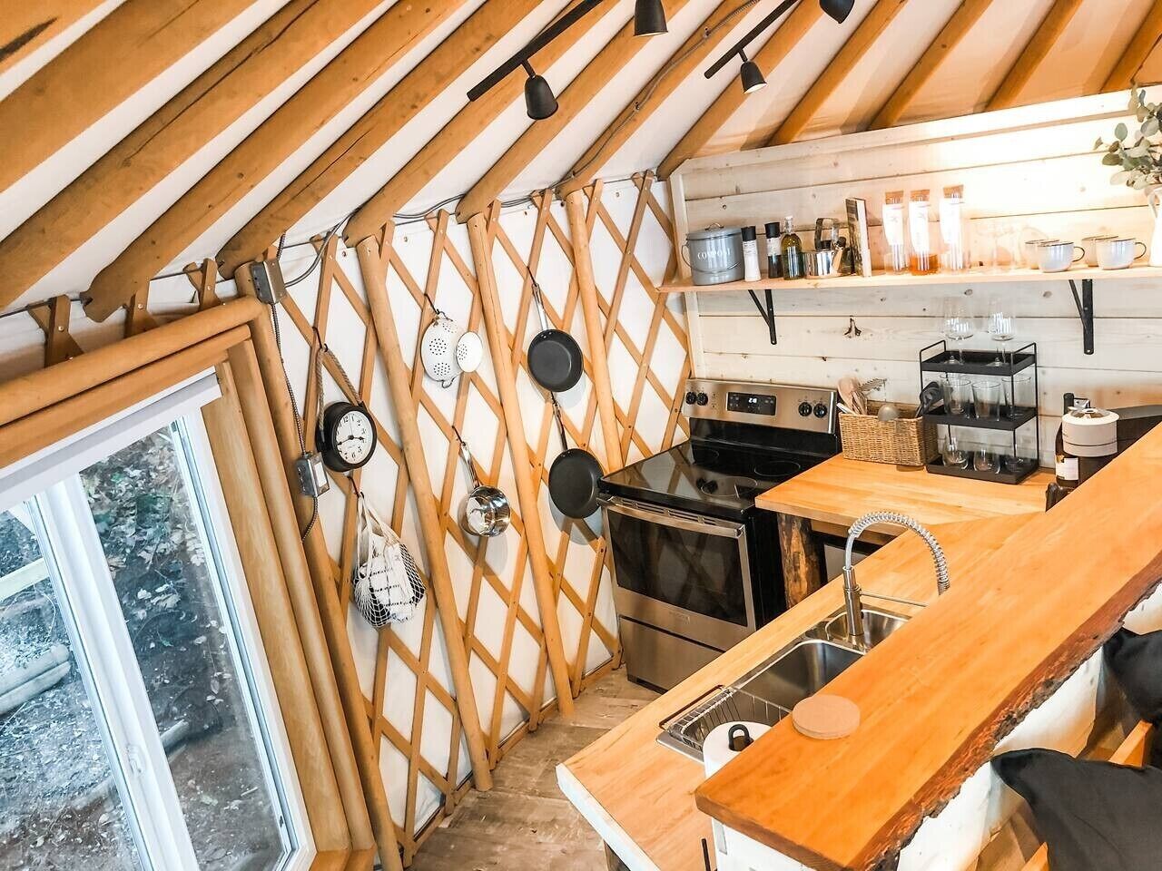 A compact kitchen with wooden beams, a stove, oven, and a sink.