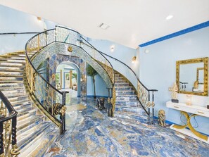 A grand staircase with ornate railings and a marble floor.
