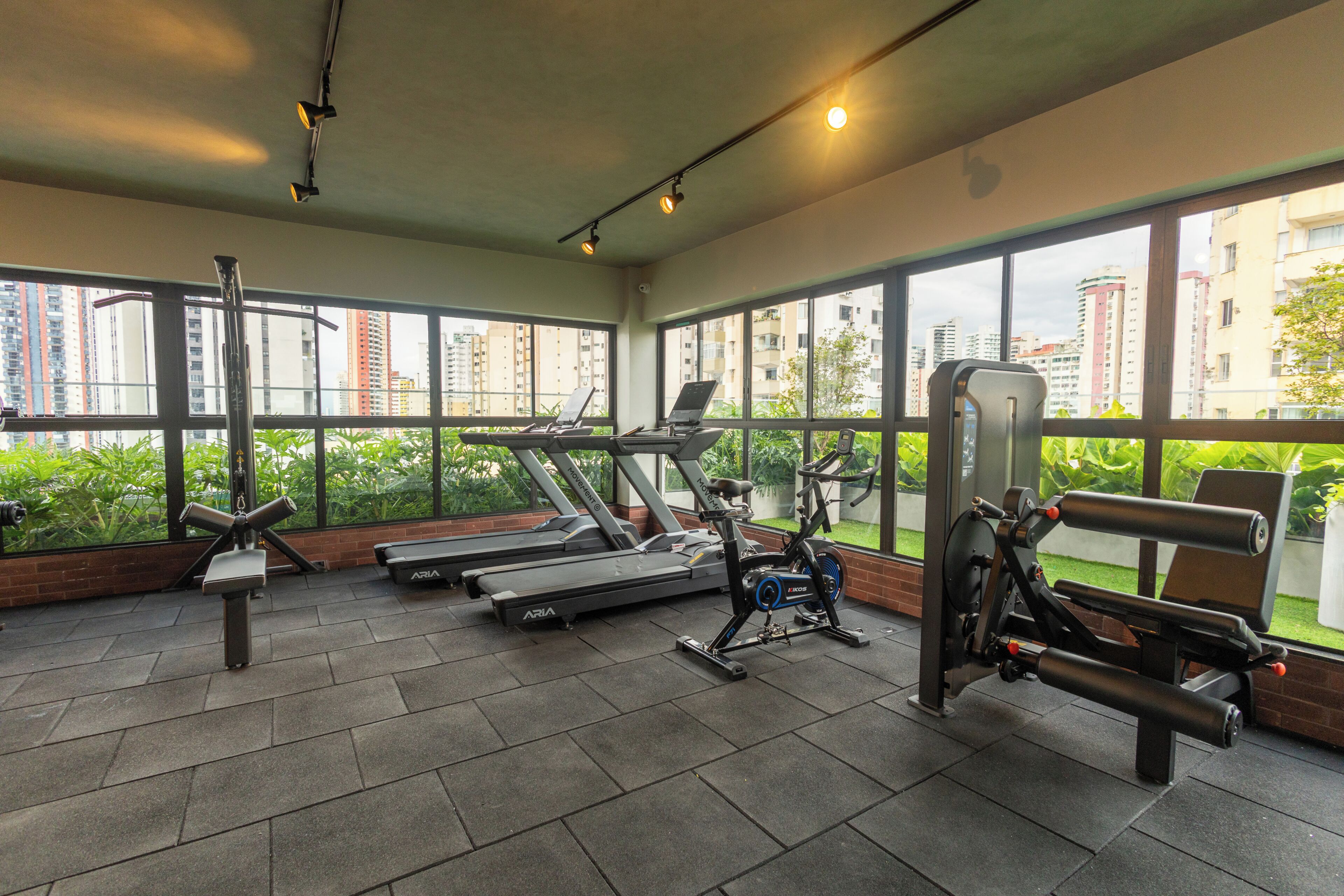 Une salle de sport équipée de tapis de course, de vélos d’appartement et d’appareils de musculation.