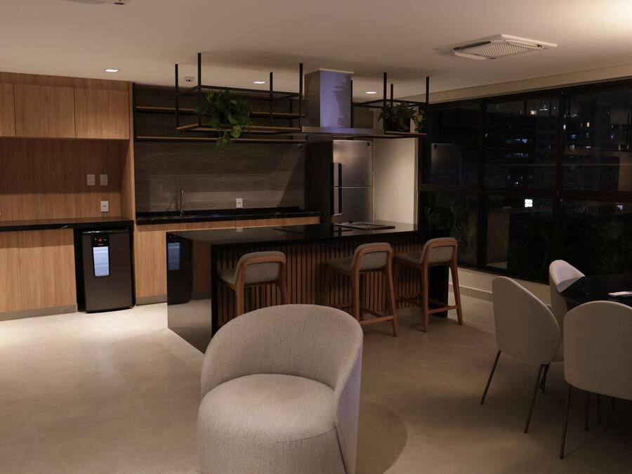 A modern kitchen with a built-in refrigerator, a stove, and a sink. There are wooden cabinets and a countertop.