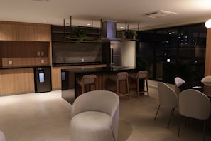 A modern kitchen with a built-in refrigerator, a stove, and a sink. There are wooden cabinets and a countertop.