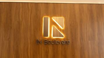 Eine Holzverkleidung mit einem Logo und der leuchtenden Aufschrift 'IN Boulevard'.