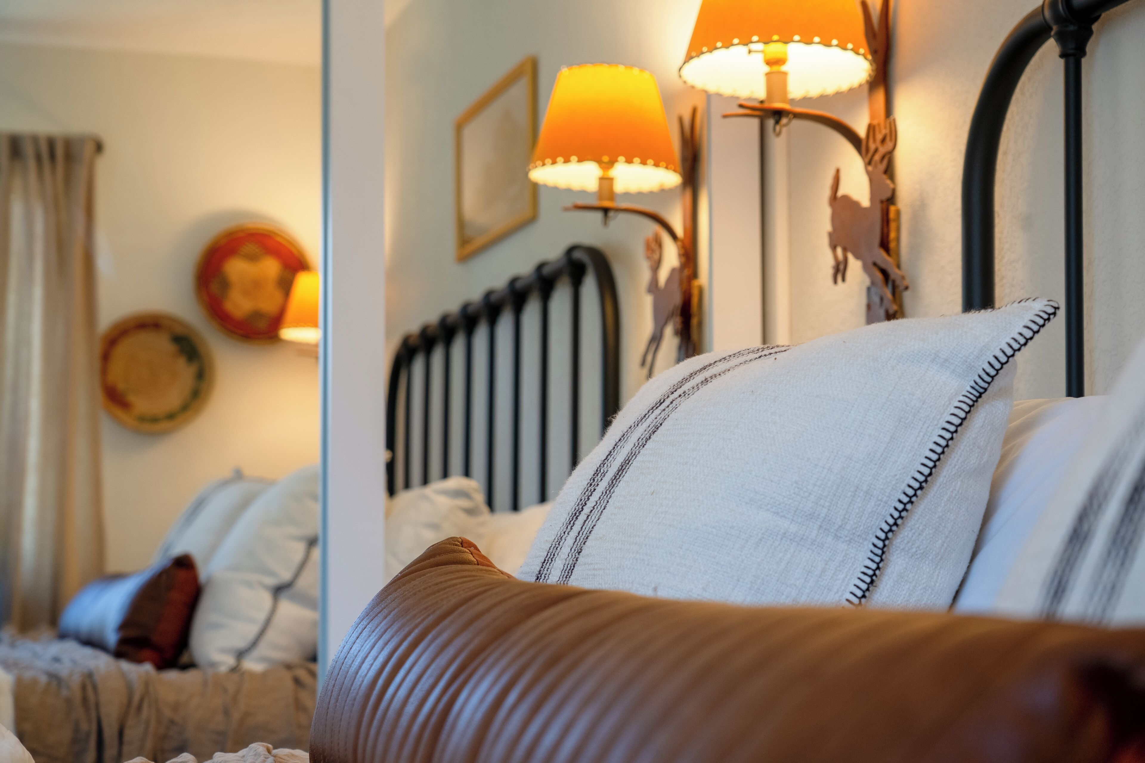 Een hotelkamer met een bed, nachtkastje en lamp.