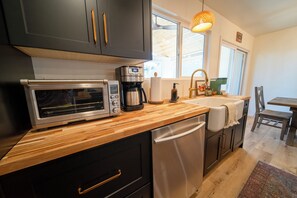 Eine moderne Küche mit einem Breville-Toasterbackofen, einer Kaffeemaschine und einem Geschirrspüler.