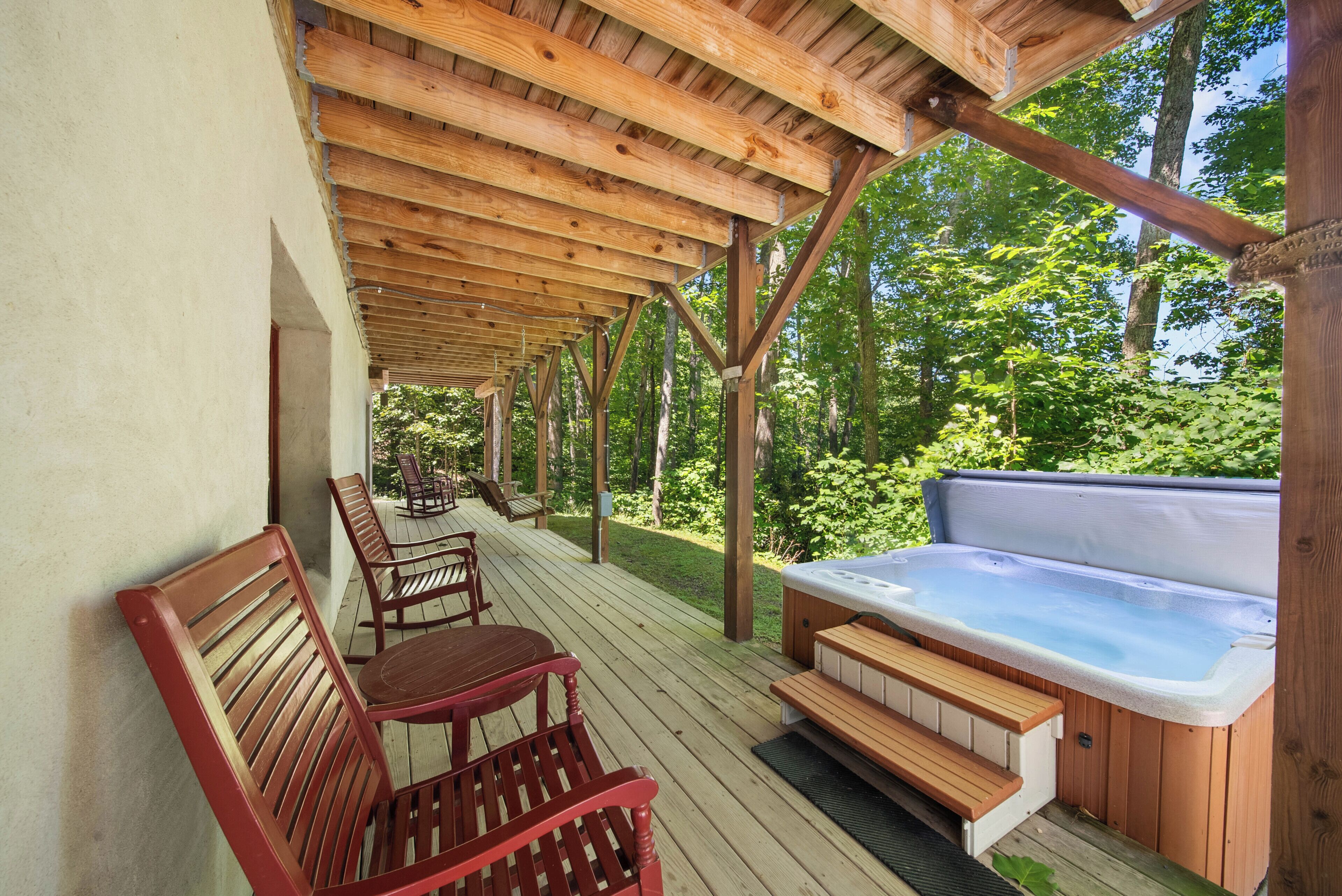 A wooden deck with a hot tub and seating area.