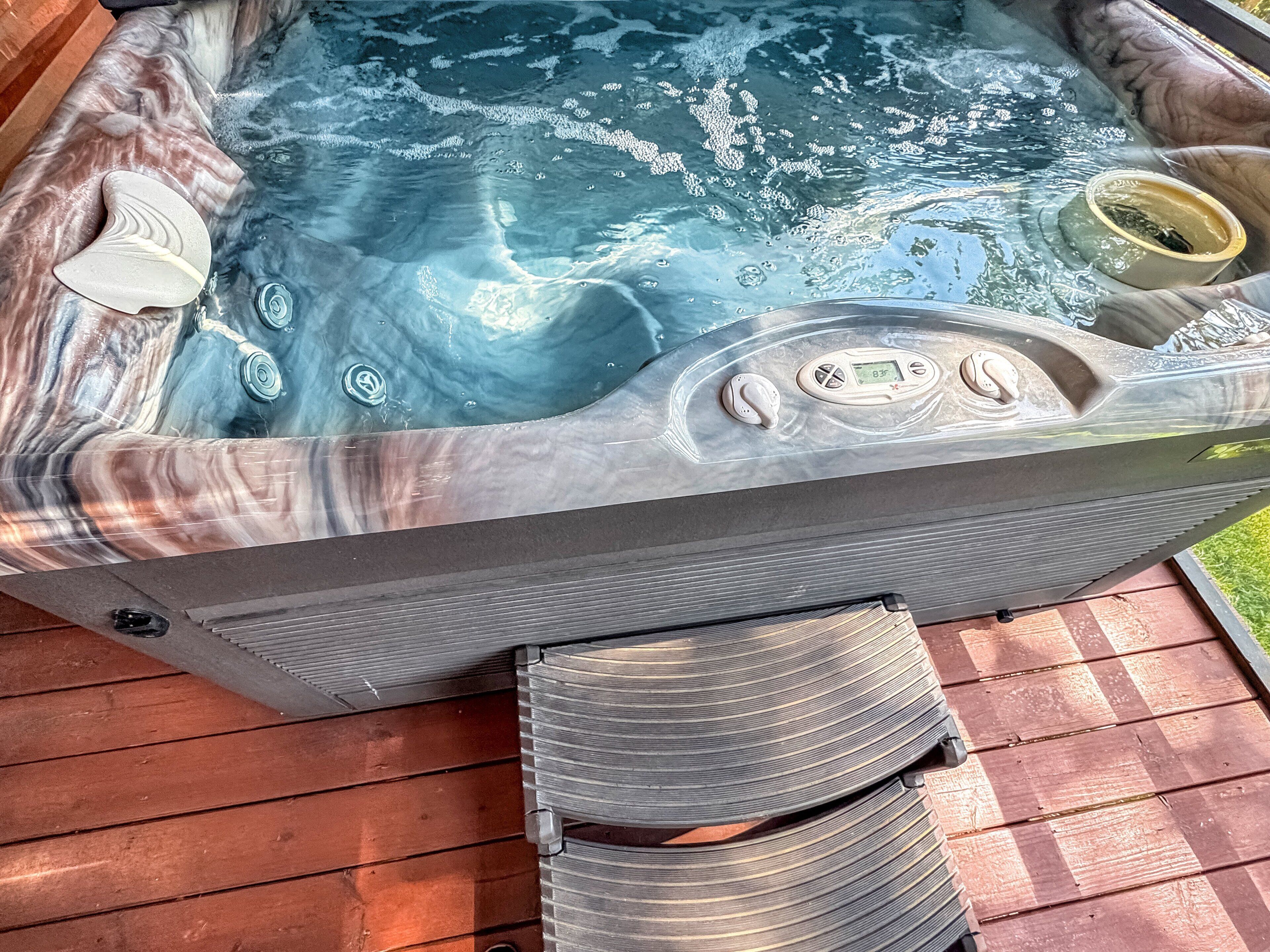 A hot tub with a control panel and a cup on the edge.