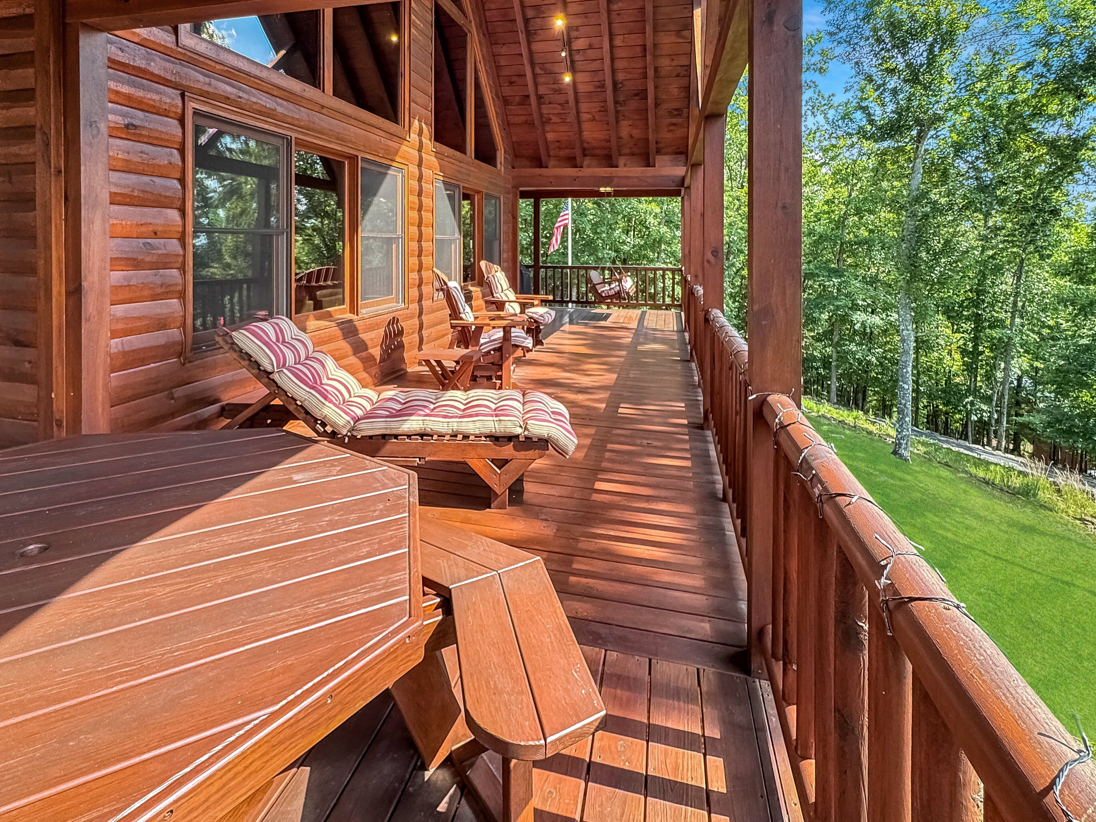 A wooden deck with outdoor seating and a view of a green landscape.