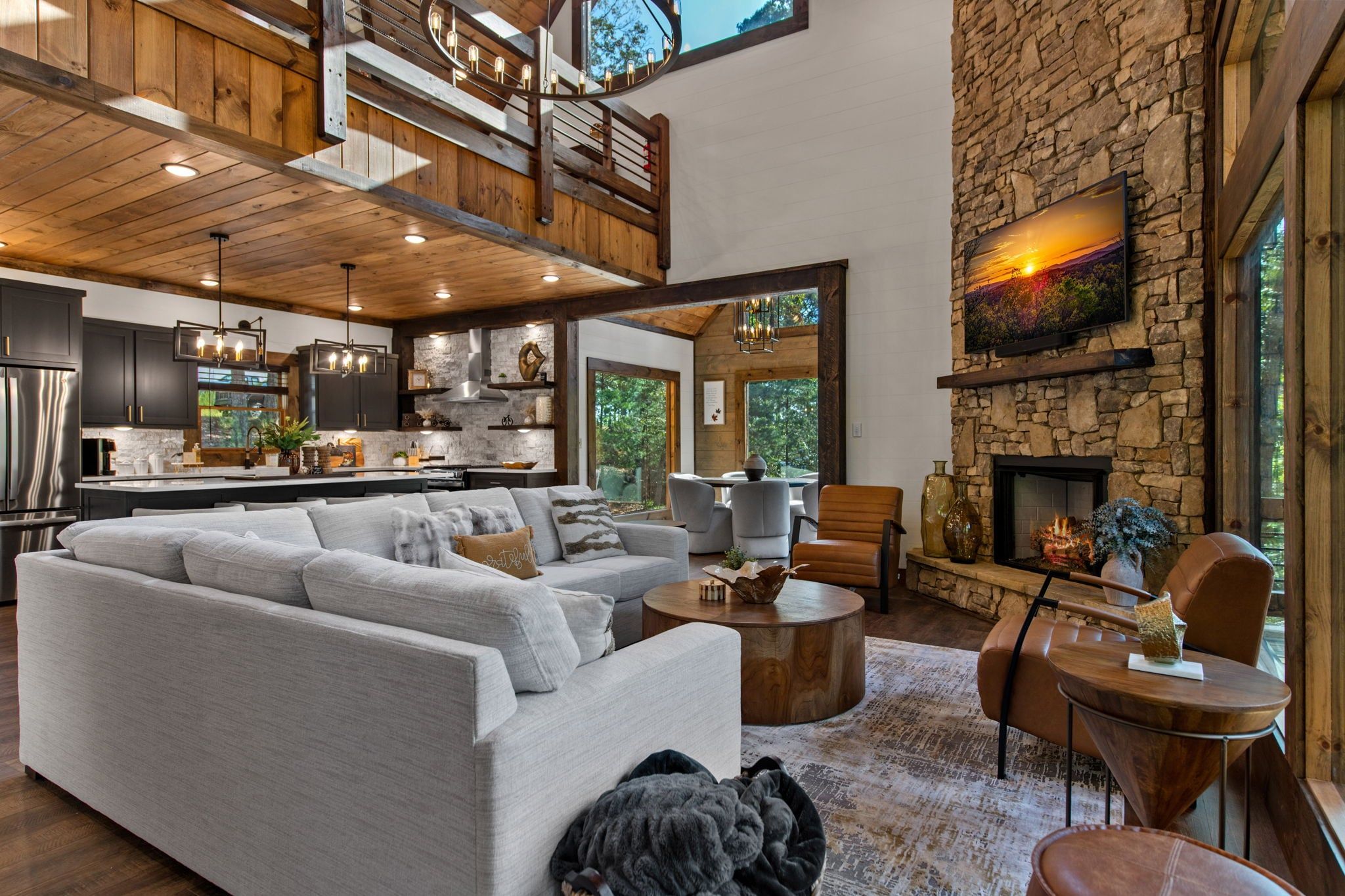 A spacious living area with a large sofa, a fireplace, and a kitchen in the background.