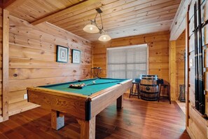 A wooden-paneled room with a pool table, a window with blinds, and a ceiling fan. - Gatlinburg: 4 King Ensuites, Hot Tub, Pool Table (Gatlinburg)