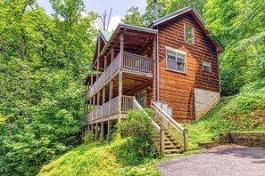 A wooden cabin with a balcony and a staircase leading to the entrance. - Gatlinburg: 4 King Ensuites, Hot Tub, Pool Table (Gatlinburg)