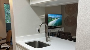A modern kitchen with white cabinetry, a stainless steel sink, and a built-in dishwasher. - Cozy Avalon 1-bedroom in beautiful Clearwater-newly remodeled (Clearwater)