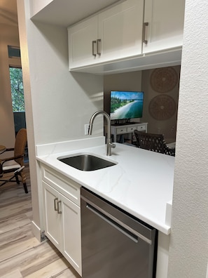 A modern kitchen with white cabinetry, a stainless steel sink, and a built-in dishwasher. - Cozy Avalon 1-bedroom in beautiful Clearwater-newly remodeled (Clearwater)