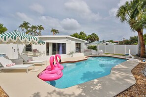 Ein Schwimmbecken mit Liegestühlen und einem Flamingo-Schwimmpferd.