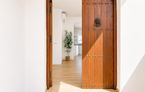 A hallway with a wooden door and a potted plant. - Awesome home in Nerja with private swimming pool, can be inside or outside (Nerja)