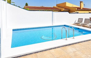 A rectangular swimming pool with a blue tiled interior, a white border, and a decorative edge. There are two metal pool ladders on one side. The pool is surrounded by a white wall with a decorative border. - Awesome home in Nerja with private swimming pool, can be inside or outside (Nerja)