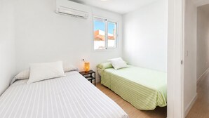 A bedroom with two beds, a window, and an air conditioning unit. - Awesome home in Nerja with private swimming pool, can be inside or outside (Nerja)