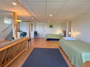 A room with a desk, two beds, a chair, and a staircase. - The Blue Pearl. Charming 3-bedroom house in adorable Lubec! (Lubec)