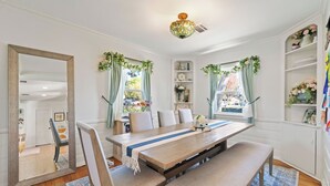 A dining area with a wooden table, benches, and a mirror. - Spacious 4-bedroom house in charming Toluca Woods (Los Angeles)