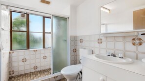 A bathroom with a toilet, sink, and shower area. - Sandcastles 231 - across the street from Park Beach in Coffs Harbour (Coffs Harbour)