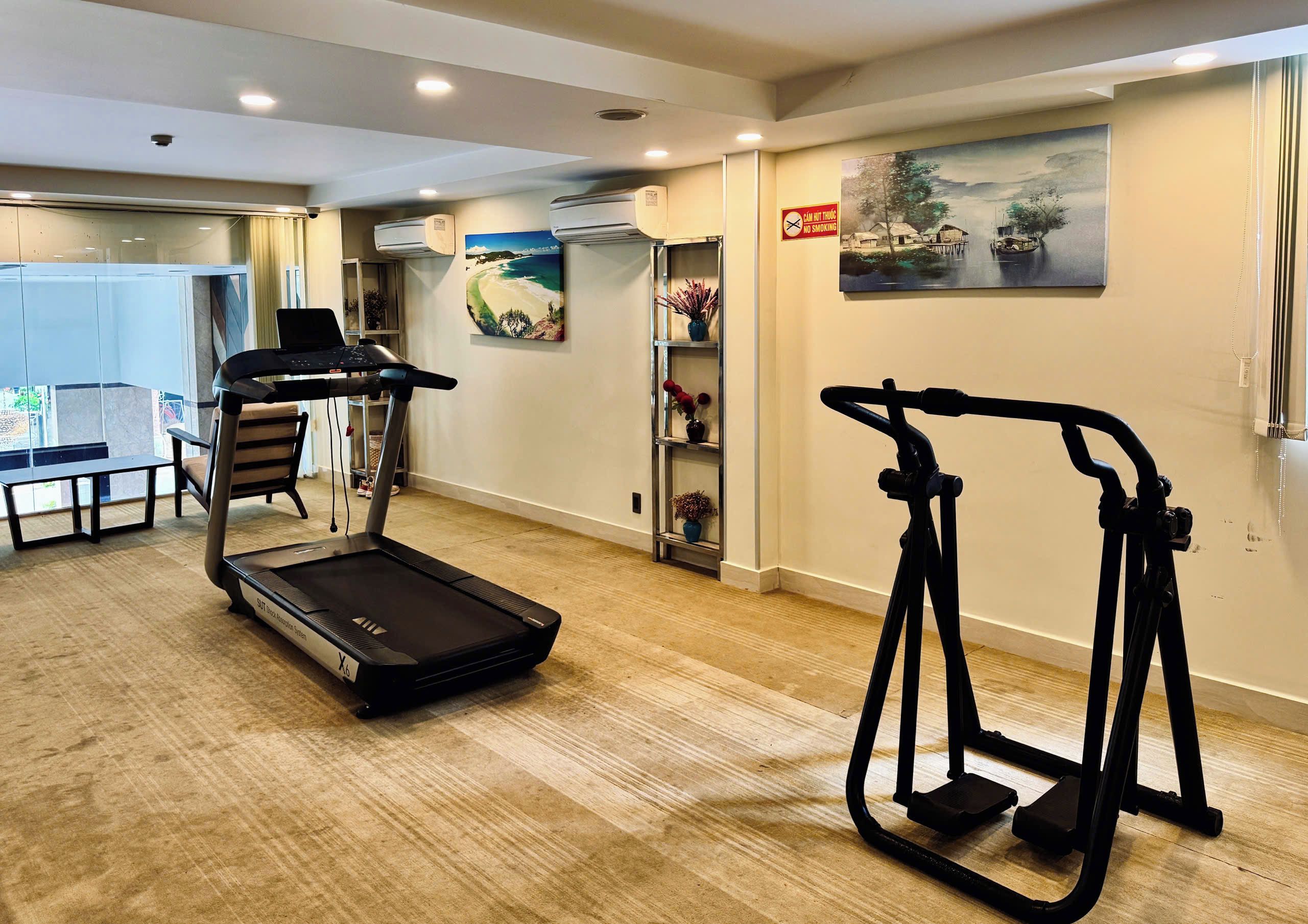 A fitness room with a treadmill, elliptical, and stationary bike.