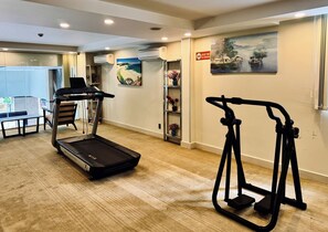Gimnasio con cinta de correr, elíptica y bicicleta estática.
