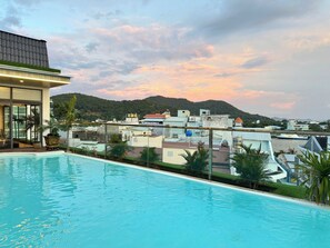 A swimming pool with a view of a cityscape and mountains in the background.