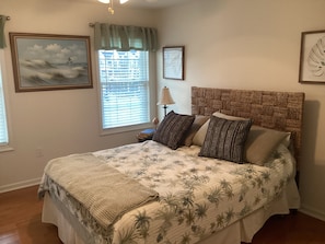 A bedroom with a bed, a nightstand, a lamp, and a window with blinds. - Spacious 3br/2bth Wildwood Condo — Walk to the Beach, Boardwalk & Downtown! (Wildwood)