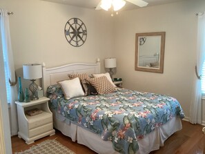 A bedroom with a bed, nightstands, a lamp, a compass wall decoration, and a framed picture. - Spacious 3br/2bth Wildwood Condo — Walk to the Beach, Boardwalk & Downtown! (Wildwood)