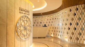 A modern reception area with a circular design, a reception desk, and a patterned wall. - Garza Blanca Resort and Spa (Punta Sam)