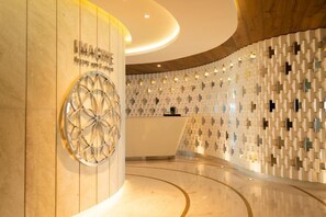 Un área de recepción moderna con un diseño circular, una mesa de recepción y una pared con diseño.