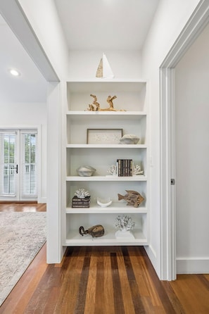 A white shelving unit with various decorative items and a framed picture. - Magnolia Cottages on 30A: 5-Min Walk to the Beach! 2 King Beds, Bunk Room (Inlet Beach)