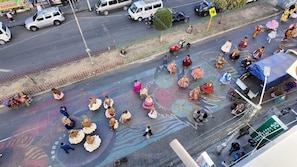 Una calle con un grupo de personas vestidas con atuendo tradicional, una camioneta blanca y un cartel.