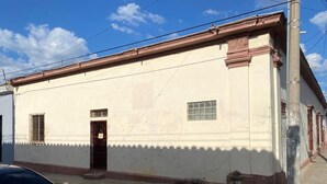 Un edificio de fachada plana, con una puerta y un ventanal.