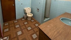 A bathroom with a toilet, sink, and shower.