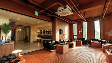 A spacious lobby with a brick floor, a reception desk, and a seating area with sofas and tables.