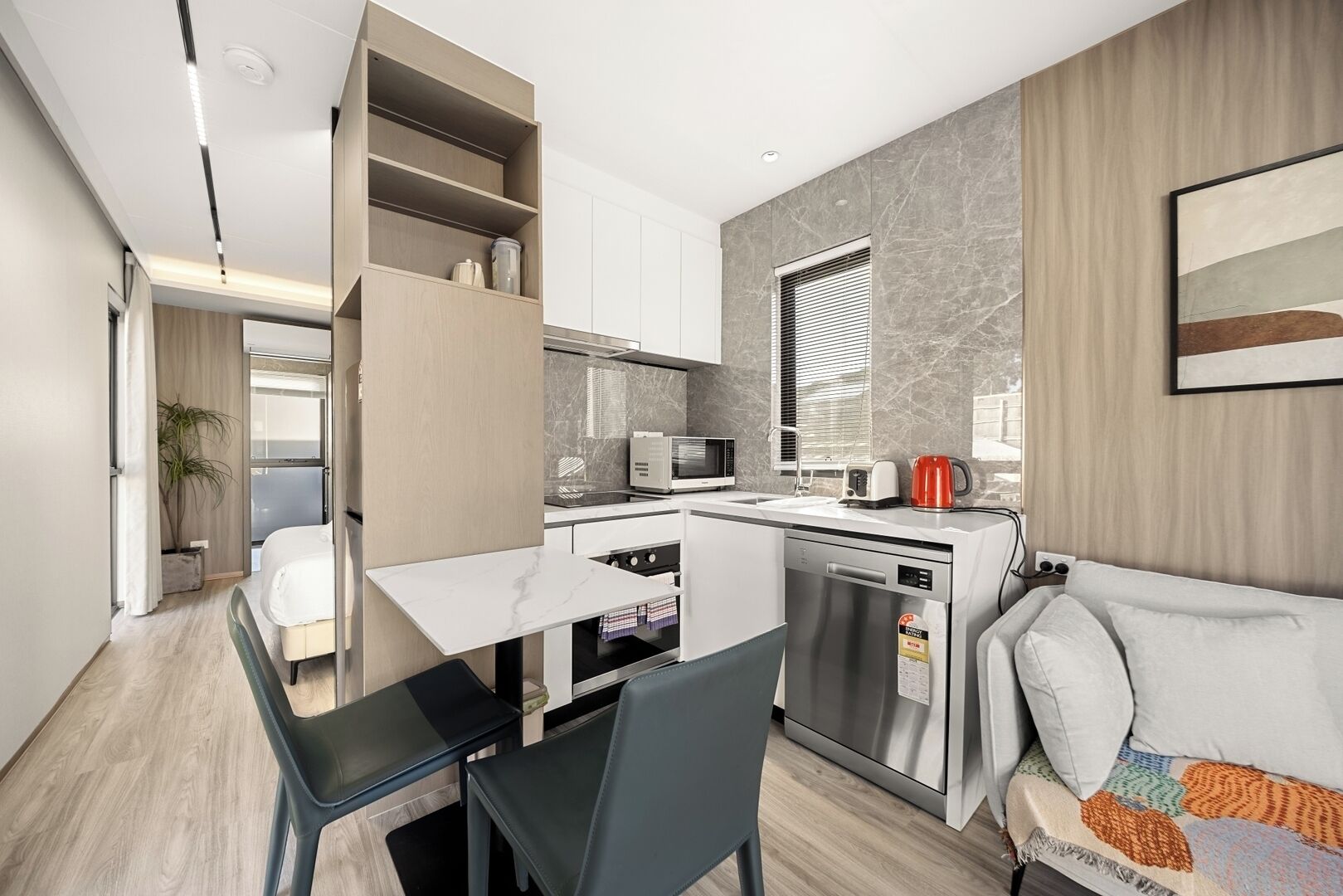 A compact kitchen with a dining area, a built-in microwave, a coffee maker, and a dishwasher.