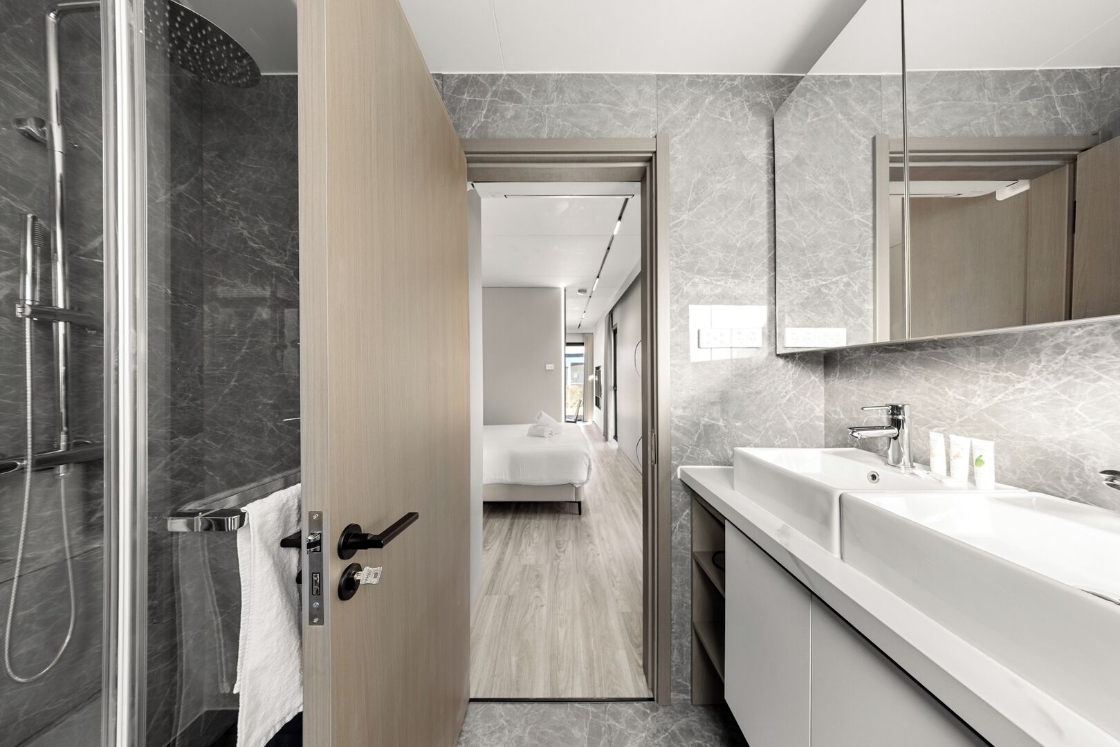 A modern bathroom with a shower, a sink, and a mirror.