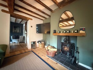 A cozy living room with a fireplace, a television mounted on the wall, and a comfortable seating area.