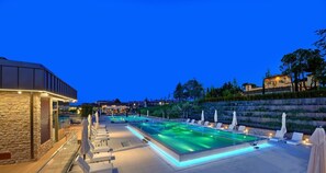 A pool area with lounge chairs and umbrellas, surrounded by stone walls and vegetation. - Villa Lampina - private villa on luxury estate (Varignana-Palesio)