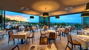 An indoor dining area with tables and chairs, large windows, and pendant lighting. - Villa Lampina - private villa on luxury estate (Varignana-Palesio)