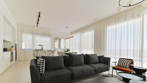 A modern living room with a sectional sofa, a coffee table, and a dining area with a table and chairs. - Villa Basia with private pool in Ciovo Island (Okrug Gornji)