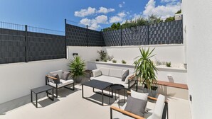 An outdoor patio with a sofa, chairs, a table, and potted plants. - Villa Basia with private pool in Ciovo Island (Okrug Gornji)