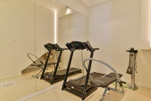 A modern gym with two treadmills, a stationary bike, and a mirror wall. - Villa Basia with private pool in Ciovo Island (Okrug Gornji)