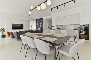 Een moderne keuken met witte kastjes, een marmeren aanrechtblad en een ingebouwde oven.
